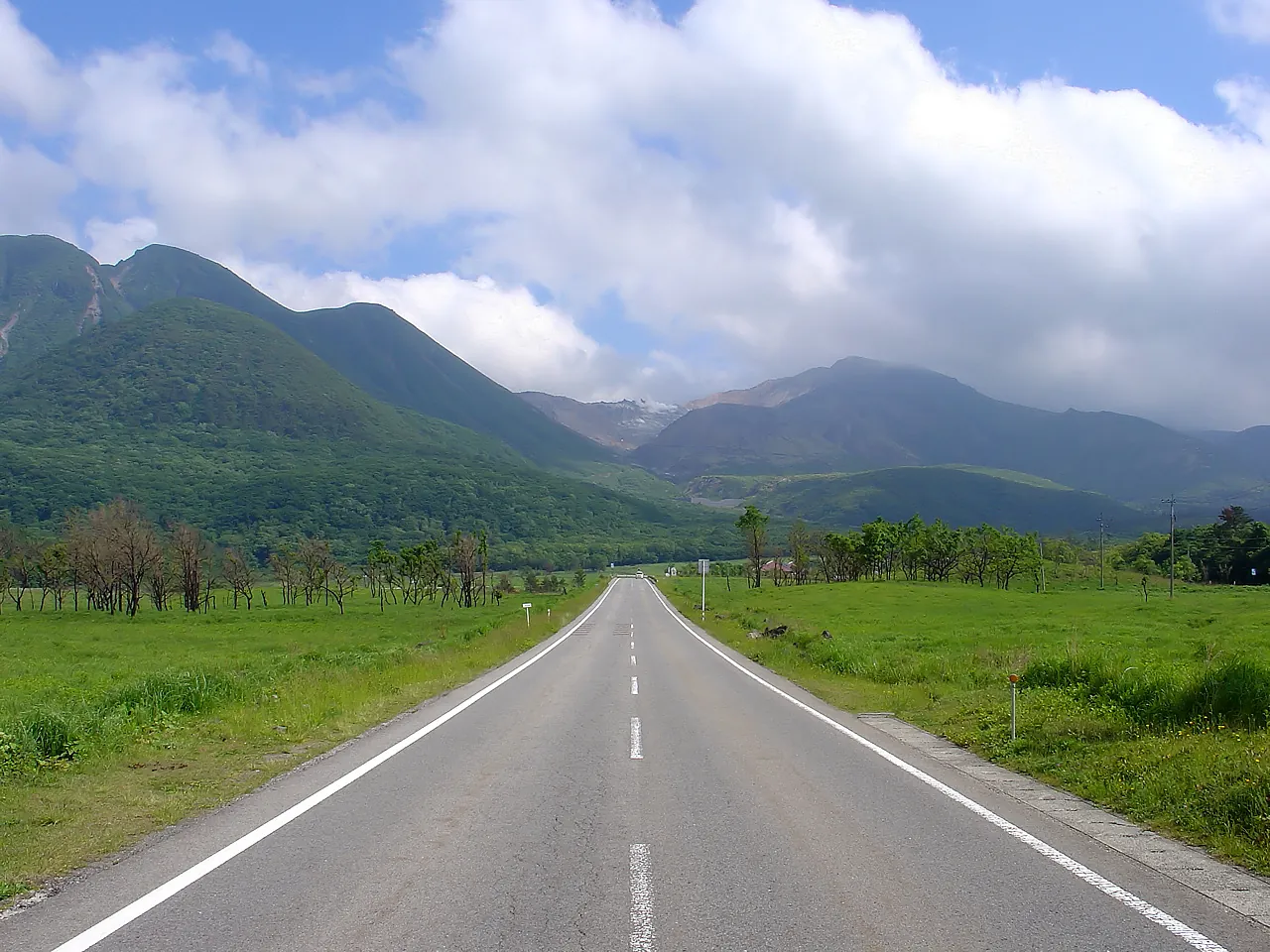 草原の中をくじゅうの山へまっすぐ延びる道