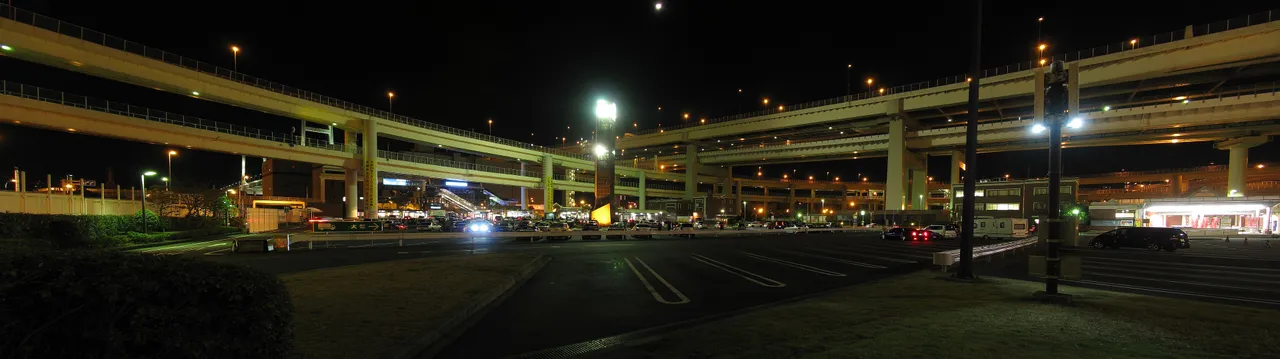 The Daikoku PA car park at night, ringed by lit expressway ramps