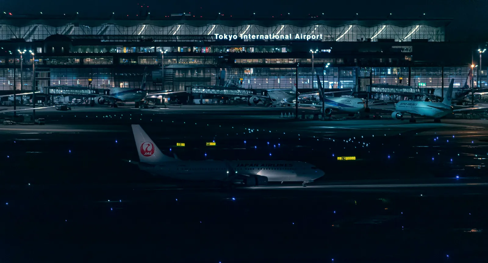 夜の羽田空港のターミナルと駐機中の飛行機